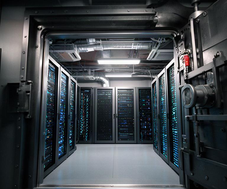 Server rack protected behind a secure data centre vault door with climate control equipment